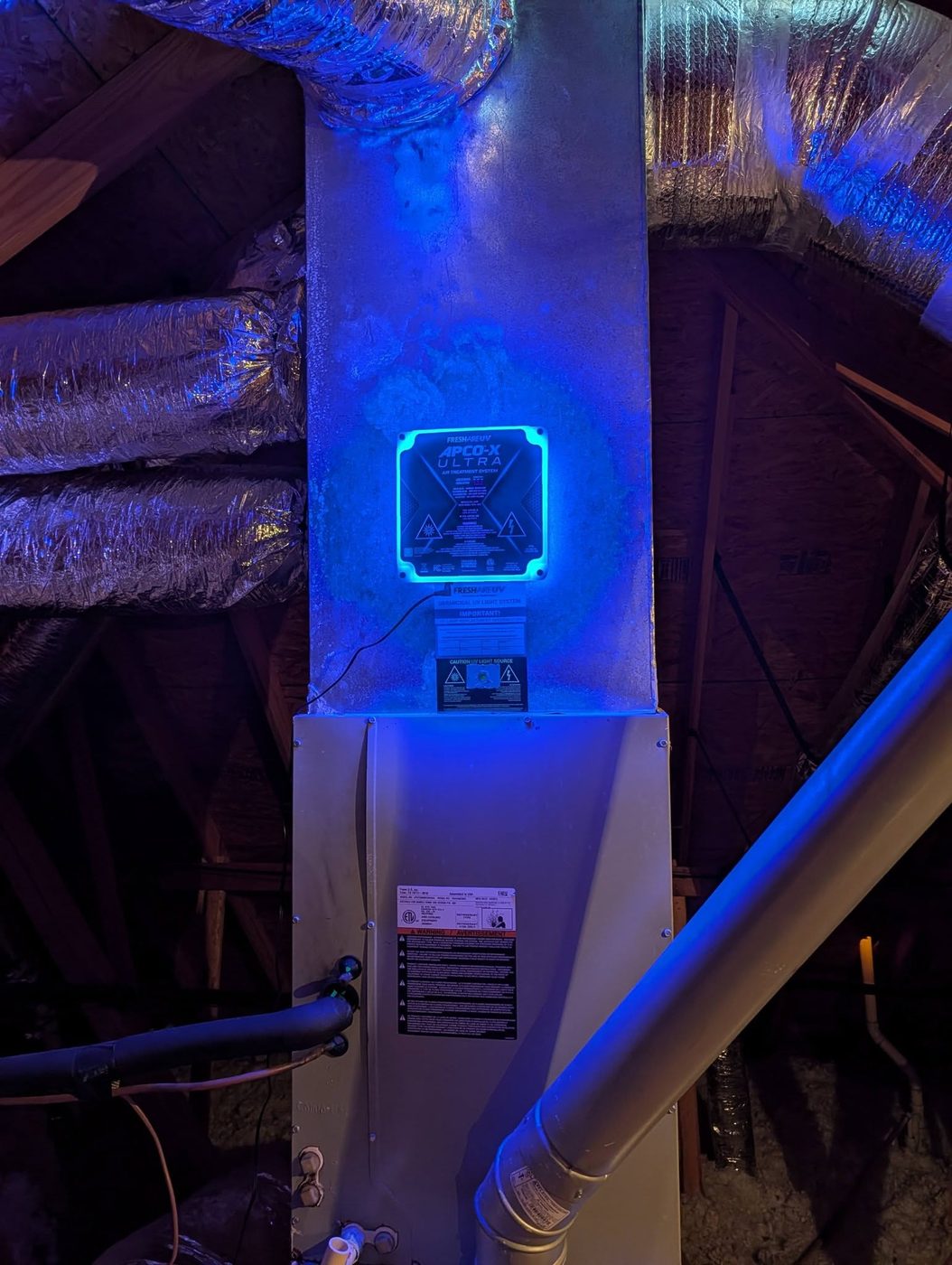 Germicidal UV light system installed on an HVAC unit, glowing blue